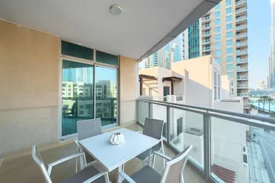 a balcony with a white table and chairs on it at Burj Khalifa & Fountain View - Downtown - 2BR in Dubai