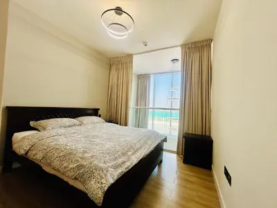 a bedroom with a bed and a large window at Modern brand new Loft Townhouse in Dubai in Dubai
