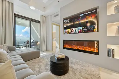 a living room with a couch and a fireplace at DAMAC Aykon Tower - High-Floor Luxury 2-Bedroom Apartment in Dubai