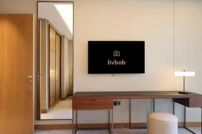 a room with a desk and a tv on a wall at 3B in Downtown with Burj Khalifa View Near Dubai Mall and Opera District in Dubai