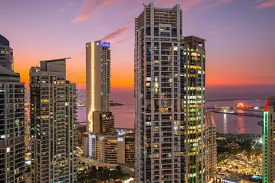 a city skyline with tall buildings at night at FIRST CLASS 2BR Marina, Sea & Ain Views in Dubai