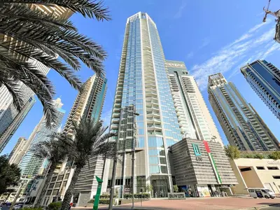 a tall building with a palm tree in front of it at FIRST CLASS 2BR Marina, Sea & Ain Views in Dubai