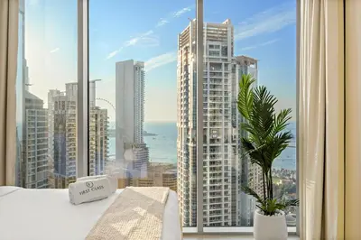 a bedroom with a large window with a view of the city at FIRST CLASS 2BR Marina, Sea & Ain Views in Dubai