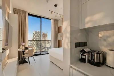 a hotel room with a bed and a large window at Modern Studio Apartment in Binghatti Tulip with Pool, Parking, Gym in Dubai