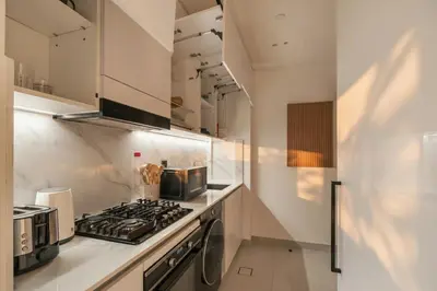 a kitchen with a stove top oven next to a counter at Modern Studio Apartment in Binghatti Tulip with Pool, Parking, Gym in Dubai