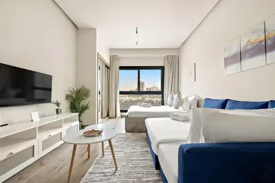 a living room with a couch and a tv at FIRST CLASS Studio Charming Cozy Comfort in Dubai