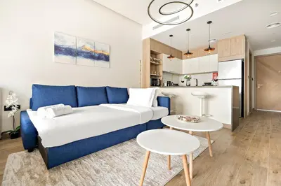a living room with a blue couch and two tables at FIRST CLASS Studio Charming Cozy Comfort in Dubai
