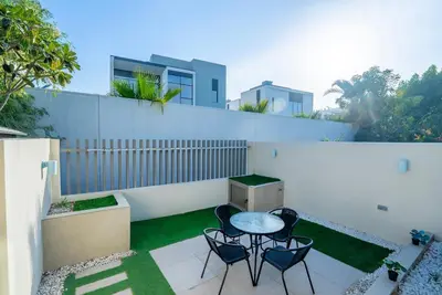 a patio with four chairs and a table on a white wall at Executive 4BR Townhouse - Al Furjan in Dubai