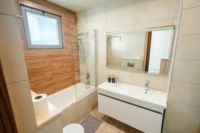 a bathroom with a sink and a tub and a mirror at Executive 4BR Townhouse - Al Furjan in Dubai