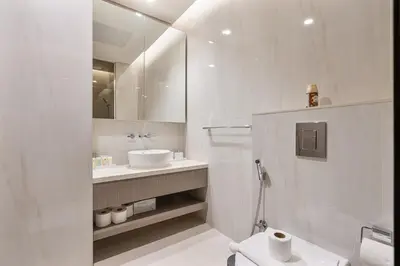 a white bathroom with a sink and a mirror at Elegant Studio with Iconic Burj Khalifa Views in Dubai