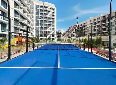 a tennis court in the middle of a city at Dubai Miracle Garden Modern Luxury Studio Pool, Padel Court & Sauna Arjan in Dubai