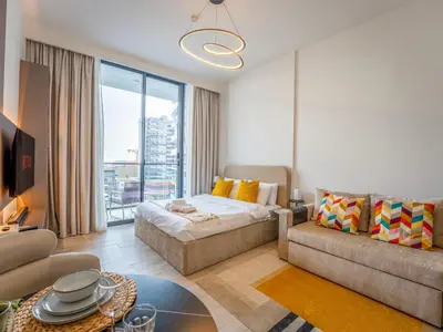 a living room with a bed and a couch at Dubai Miracle Garden Modern Luxury Studio Pool, Padel Court & Sauna Arjan in Dubai