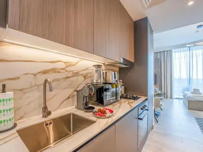 a kitchen with a sink and a microwave at Dubai Miracle Garden Modern Luxury Studio Pool, Padel Court & Sauna Arjan in Dubai