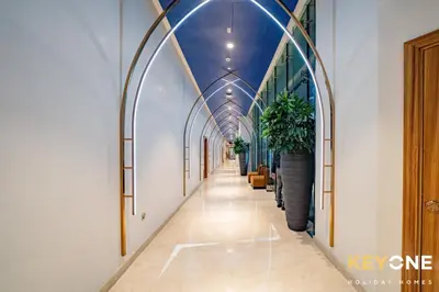 an aisle in a building with arches and potted plants at Sleek Studio in Privé with Stunning Canal View in Dubai