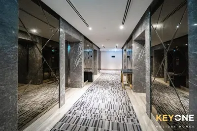 a hallway with marble flooring and glass walls at Sleek Studio in Privé with Stunning Canal View in Dubai