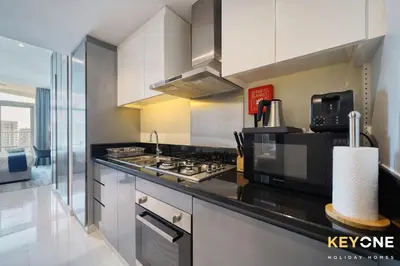 a kitchen with a stove and a microwave at Sleek Studio in Privé with Stunning Canal View in Dubai