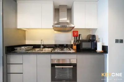 a kitchen with a sink and a stove top oven at Sleek Studio in Privé with Stunning Canal View in Dubai