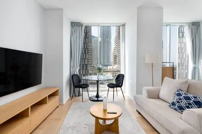 a living room with a couch and a tv and a table at Marina | Canal View Studio in Cayan Tower in Dubai