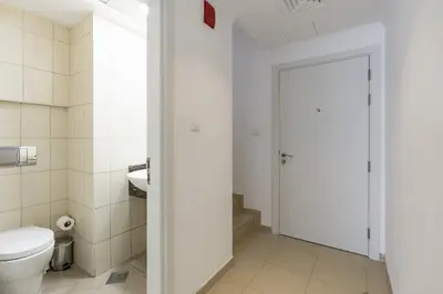 a white bathroom with a toilet and a door at Modern Comfort - Convenient - Prime JLT Living in Dubai