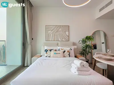 a bedroom with a white bed with towels on it at HiGuests - Peninsula Luxury 1 BR with Stunning Water Views in Dubai