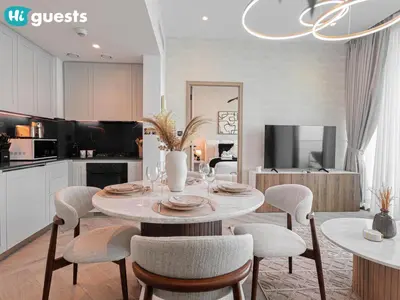 a kitchen and dining room with a table and chairs at HiGuests - Peninsula Luxury 1 BR with Stunning Water Views in Dubai