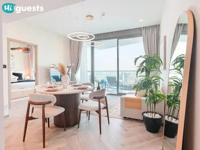 a dining room with a table and chairs in a room at HiGuests - Peninsula Luxury 1 BR with Stunning Water Views in Dubai