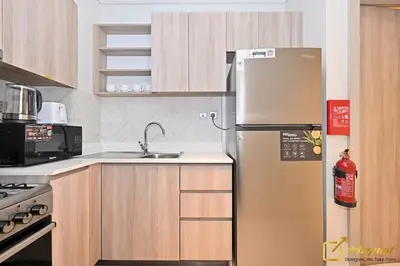 a stainless steel refrigerator in a kitchen with wooden cabinets at Luxury Studio in Dubai Hills by Deleguest in Dubai