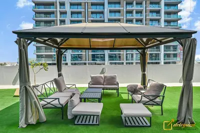 a gazebo with chairs and tables on the grass at Luxury Studio in Dubai Hills by Deleguest in Dubai