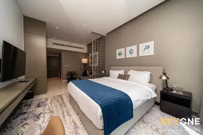 a bedroom with a large bed and a flat screen tv at Elegant Studio Living in Privé in Dubai
