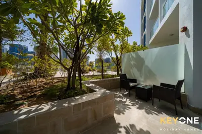 two chairs and a table next to a building at Elegant Studio Living in Privé in Dubai
