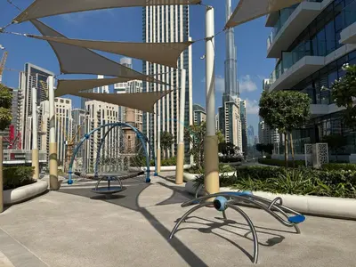 a playground in front of a city with tall buildings at Elegant 3BR, Skyline Retreat in Downtown Dubai - Imperial Avenue, Downtown Dubai by Deluxe Holiday Homes in Dubai