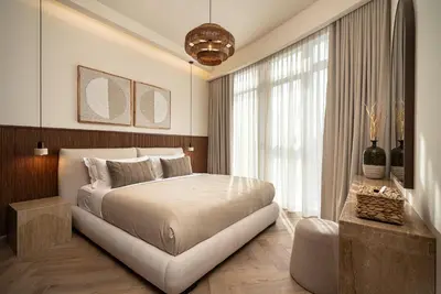 a bedroom with a large bed and a large window at Seraya Residences at Imperial Avenue Dubai in Dubai