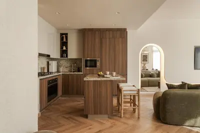 an open kitchen with a couch and a living room at Seraya Residences at Imperial Avenue Dubai in Dubai