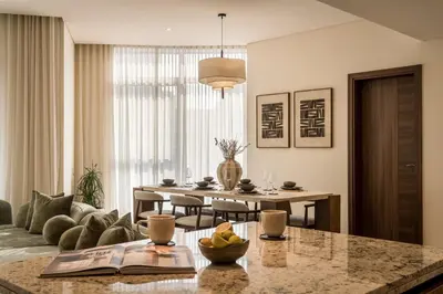 a living room with a table and a dining room at Seraya Residences at Imperial Avenue Dubai in Dubai