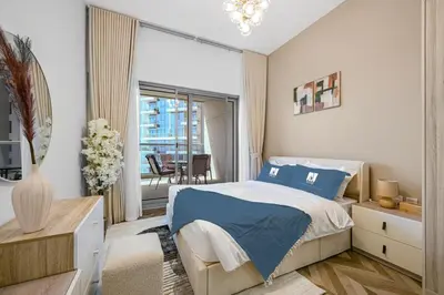 a bedroom with a bed and a balcony with a table at Spacious 1BR Elite Business Bay Residence in Dubai