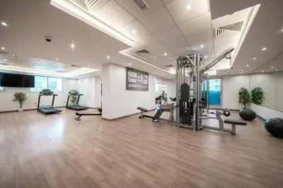 a gym with exercise equipment in a large room at Spacious 1BR Elite Business Bay Residence in Dubai