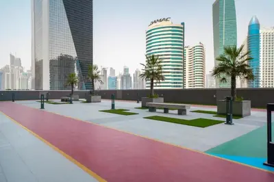 a rooftop with benches and palm trees in a city at Spacious 1BR Elite Business Bay Residence in Dubai