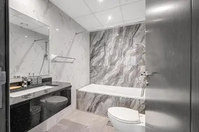 a bathroom with a toilet and a sink and a tub at Spacious 1BR Elite Business Bay Residence in Dubai