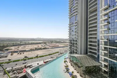 an aerial view of a building with a pool and a beach at Spacious 1BR Elite Business Bay Residence in Dubai