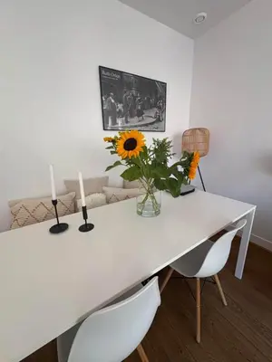 a white table with two candles and a vase of flowers at Skyline Breeze Living in Dubai