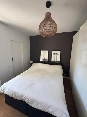 a bedroom with a white bed and a hanging light at Skyline Breeze Living in Dubai