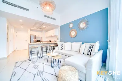 a living room with a white couch and a blue wall at Modern One Bedroom with Stylish Touches in Dubai