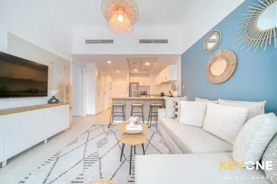 a living room with a white couch and a table at Modern One Bedroom with Stylish Touches in Dubai