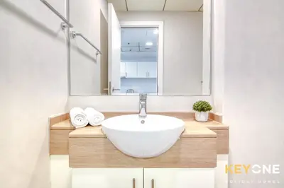 a bathroom with a sink and a mirror at Modern One Bedroom with Stylish Touches in Dubai