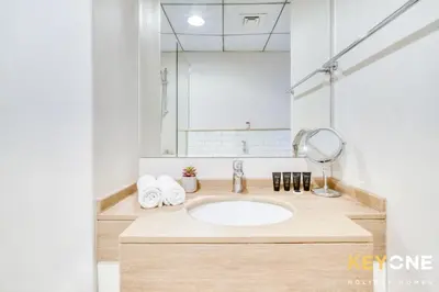 a bathroom with a sink and a mirror at Modern One Bedroom with Stylish Touches in Dubai