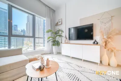 a living room with a tv and a couch at Modern One Bedroom with Stylish Touches in Dubai