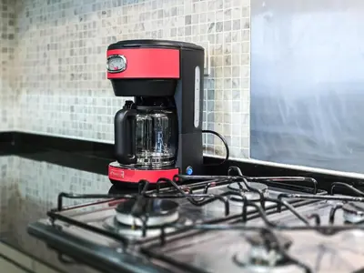 a red and black coffee maker sitting on top of a stove at Next to Dubai Mall & Burj Khalifa I Luxury Design in Dubai