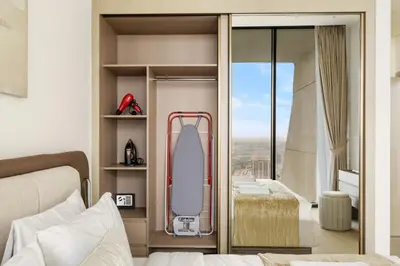 a bedroom with a bed and a surfboard on a shelf at Elevated 1BR with Private Pool at Binghatti Phantom in Dubai