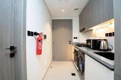a kitchen with a red fire extinguisher on the wall at Escape24 Luxury Studio 100