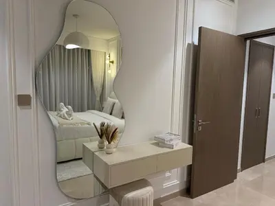 a room with a mirror and a dresser and a bed at Stunning 2BR Burj Khalifa View from Infinity Pool Grande Signature Residences in Dubai